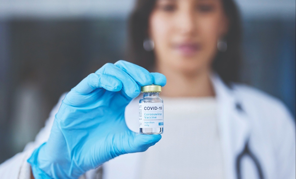 Medical professional holding COVID-19 vaccine vial.